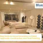 A modern, minimalist living room interior featuring curved white furniture and avant-garde decor, showcasing a professional house renovation in Dubai by Blue Bolt Maintenance.
